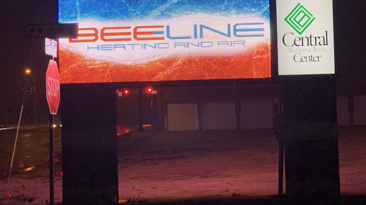 Bee Line Heating and Air lit sign glowing red and blue at night in Enid, Oklahoma