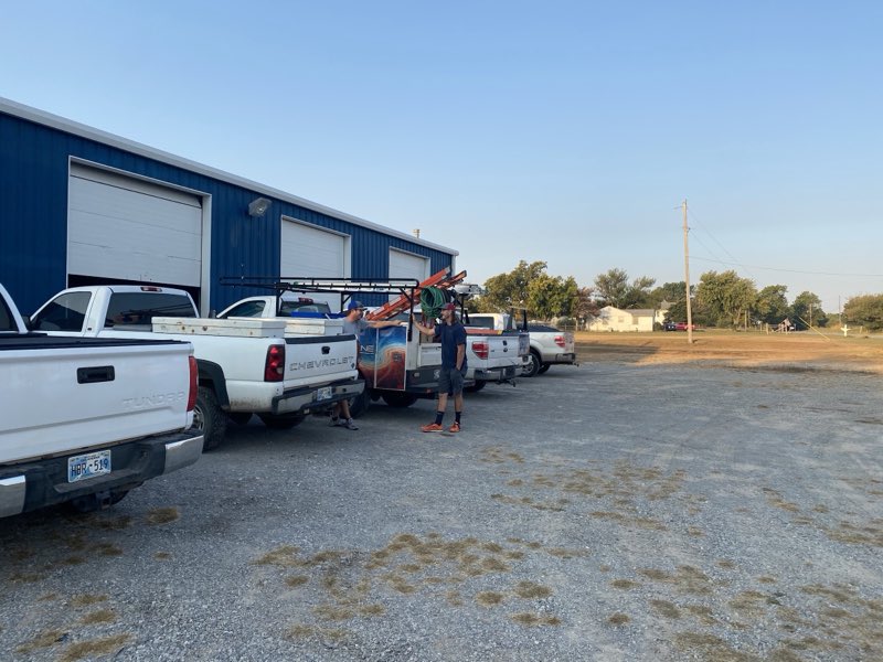 Fleet of Bee Line service trucks lined up at the shop with the crew